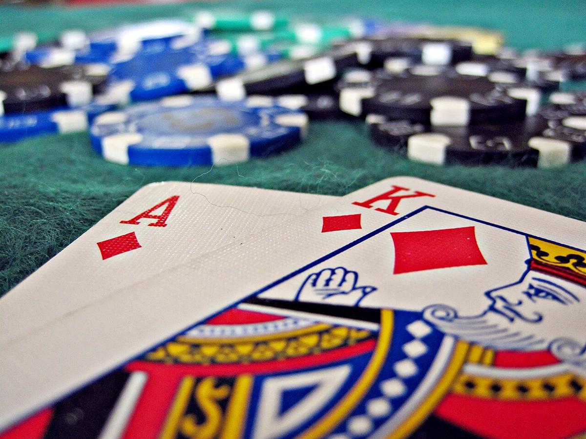 Susunan kartu blackjack dan keripik di atas meja kain hijau