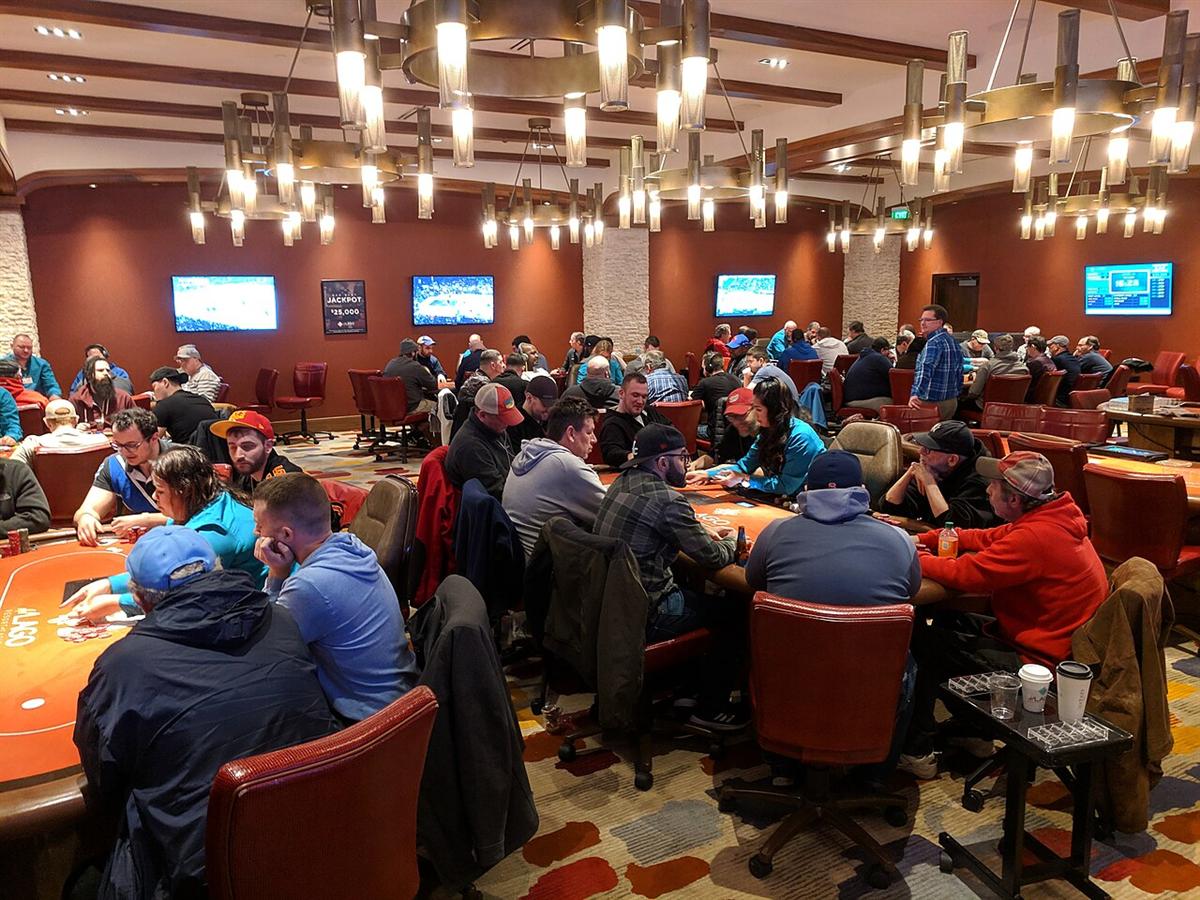 Suasana turnamen poker dengan pemain berkalung kartu di meja final